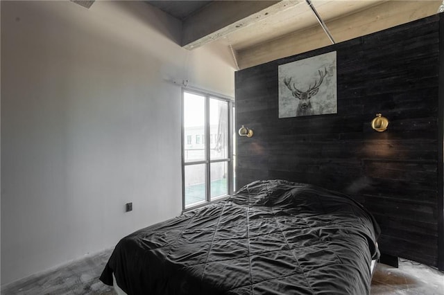 bedroom featuring wood walls and concrete flooring