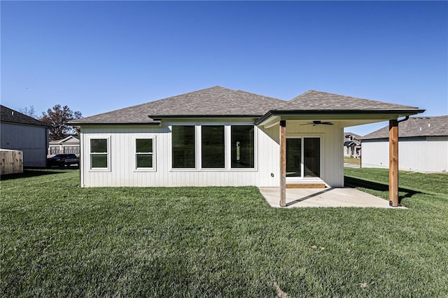 rear view of property featuring ceiling fan, a yard, and a patio area