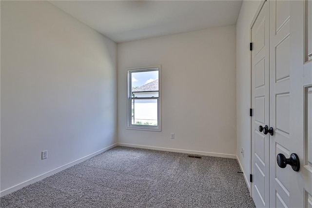 carpeted empty room with visible vents and baseboards
