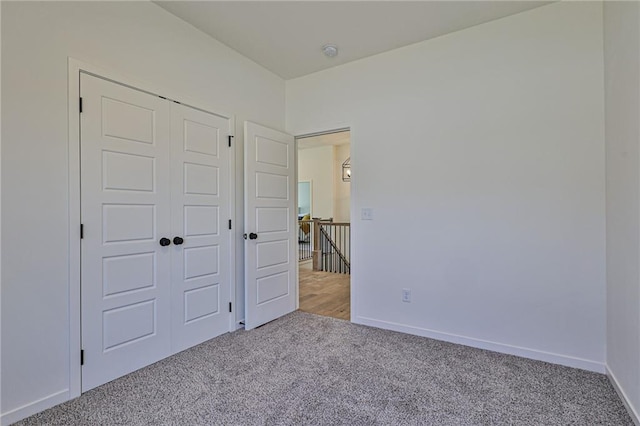 unfurnished bedroom featuring a closet, baseboards, and carpet