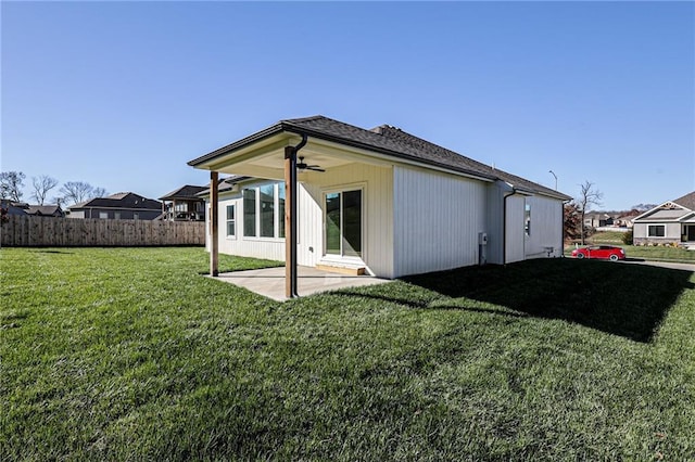 rear view of house featuring a patio, a lawn, a ceiling fan, and fence