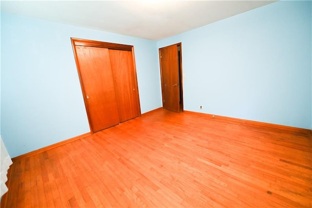 unfurnished bedroom featuring a closet and light hardwood / wood-style floors