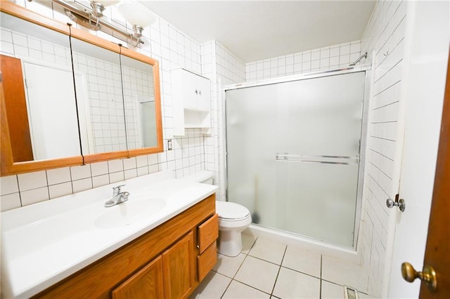 bathroom with vanity, toilet, a shower with door, and decorative backsplash