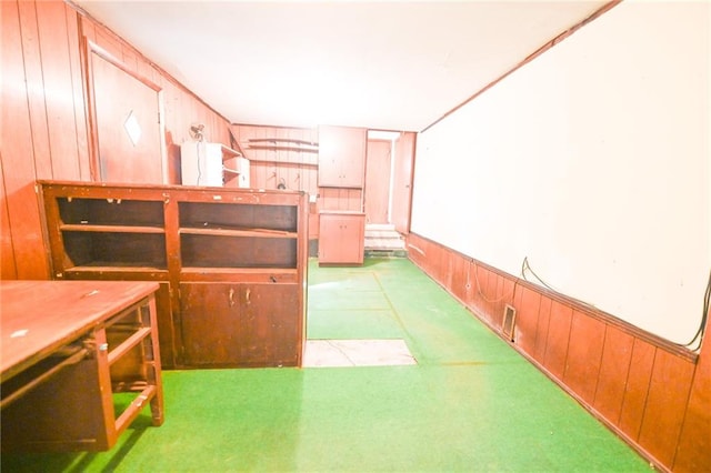 interior space featuring wooden walls and light carpet