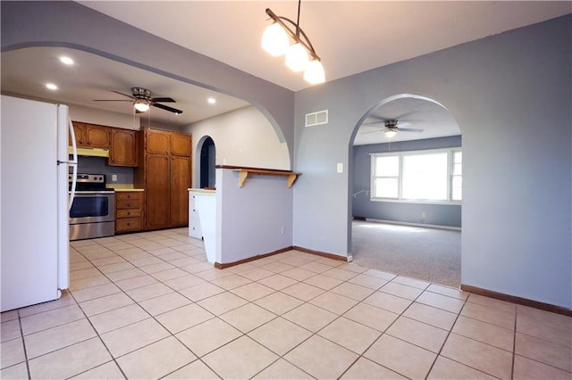 kitchen with ceiling fan, stainless steel electric stove, light tile patterned floors, and white refrigerator