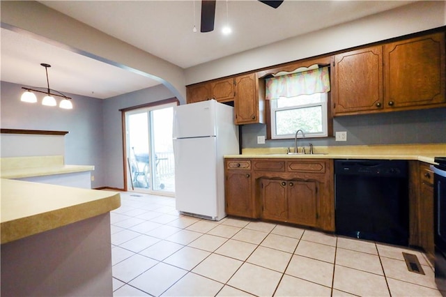 kitchen with black dishwasher, sink, hanging light fixtures, ceiling fan, and white refrigerator