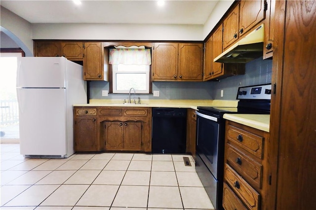 kitchen with dishwasher, backsplash, sink, white fridge, and electric stove