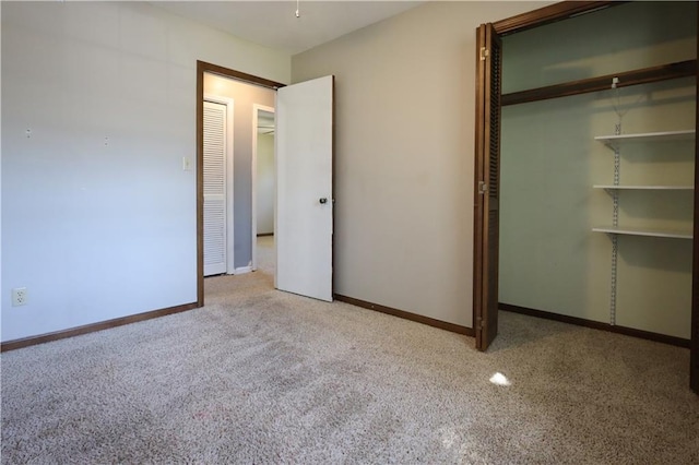 unfurnished bedroom featuring light colored carpet and a closet