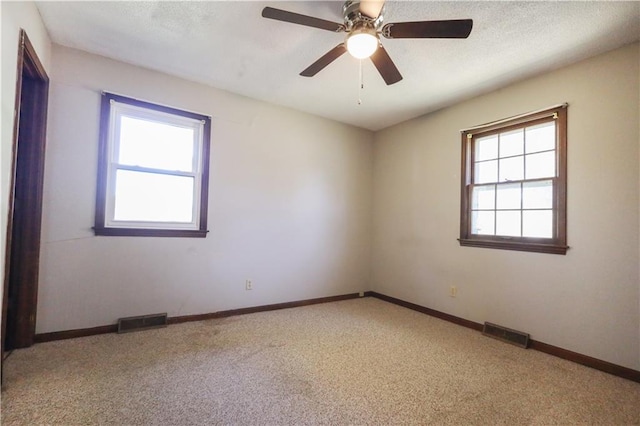 carpeted empty room featuring ceiling fan and a textured ceiling