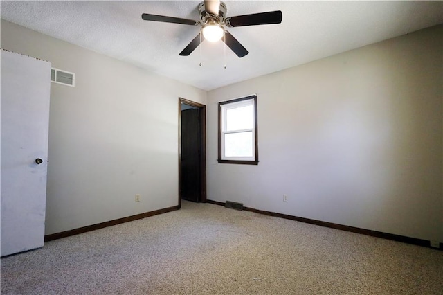 carpeted empty room featuring ceiling fan and a textured ceiling