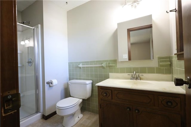 bathroom with a shower with door, tile patterned floors, toilet, tile walls, and vanity