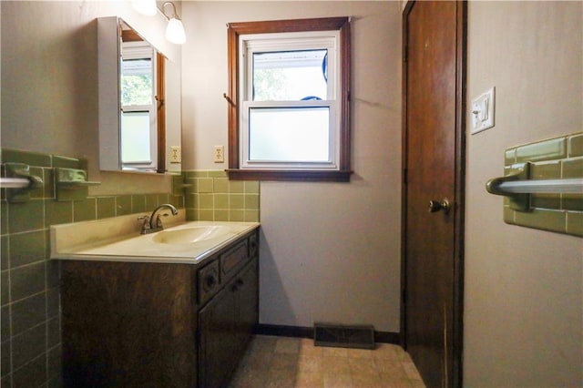 bathroom featuring tile walls, vanity, and a healthy amount of sunlight