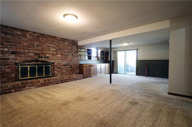 unfurnished living room with a textured ceiling, a brick fireplace, and carpet flooring