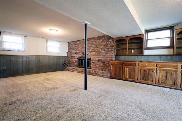 basement with light carpet, a textured ceiling, and wood walls