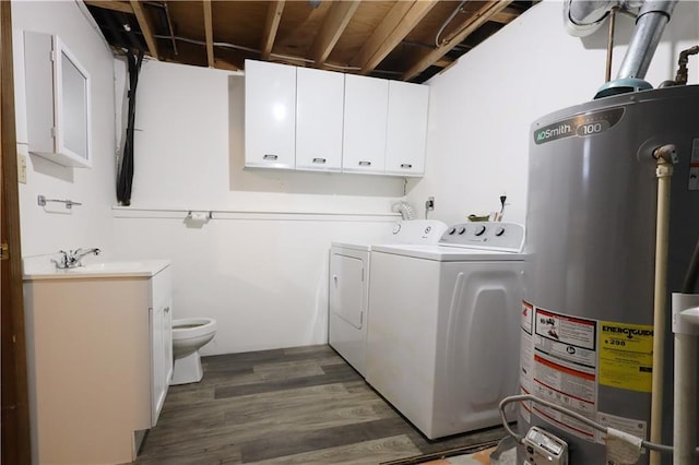 laundry area with dark hardwood / wood-style flooring, sink, washing machine and dryer, and gas water heater