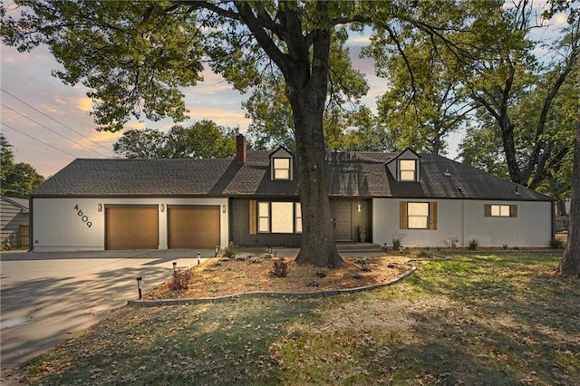 view of front of home with a garage and a lawn