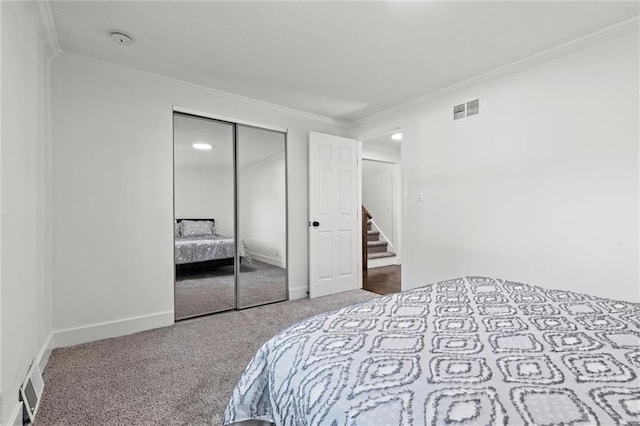 bedroom with ornamental molding, a closet, and carpet