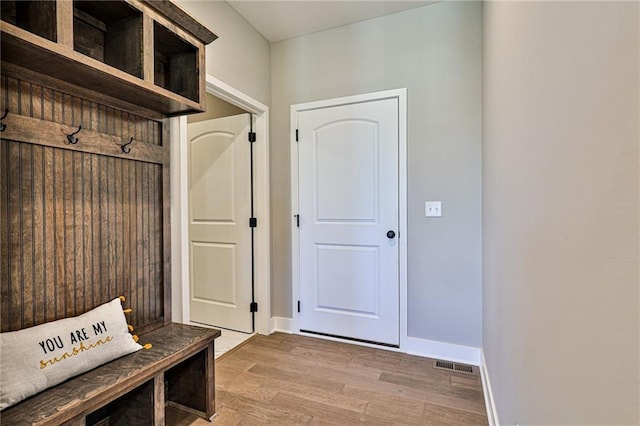 mudroom with baseboards, visible vents, and wood finished floors