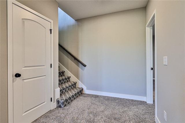 staircase featuring baseboards and carpet floors
