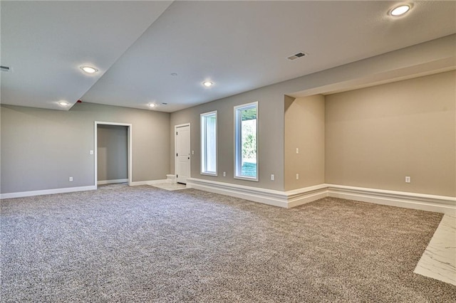 unfurnished room with carpet floors, baseboards, visible vents, and recessed lighting
