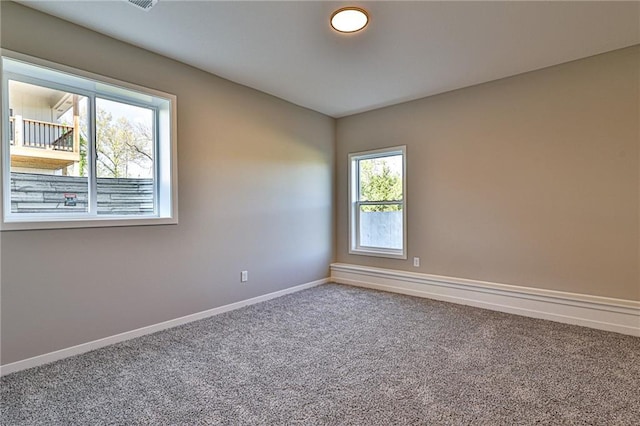 carpeted spare room featuring baseboards