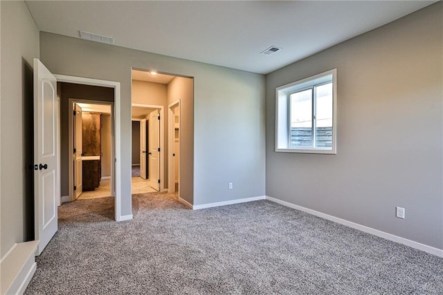 unfurnished bedroom featuring baseboards, visible vents, and carpet