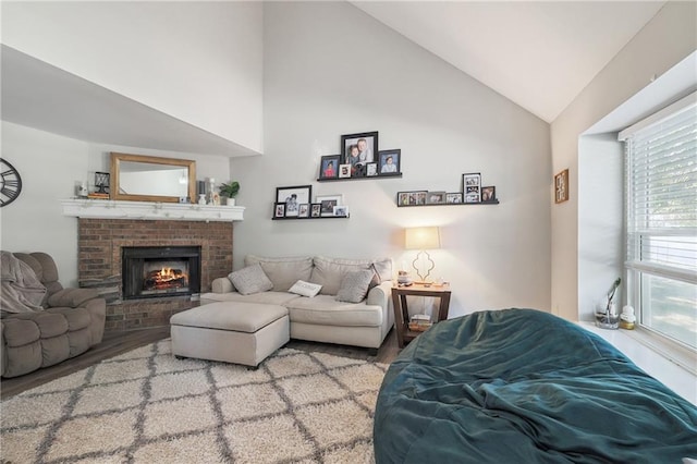 living room featuring light hardwood / wood-style flooring, a brick fireplace, and high vaulted ceiling