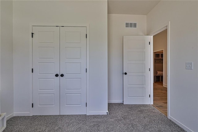 unfurnished bedroom featuring a closet, visible vents, baseboards, and carpet