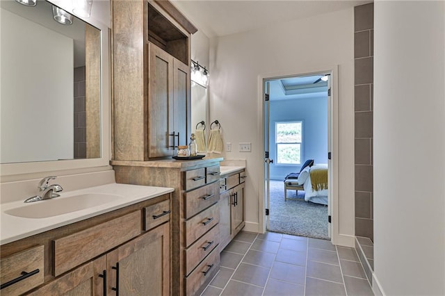bathroom with baseboards, two vanities, a sink, tile patterned floors, and connected bathroom