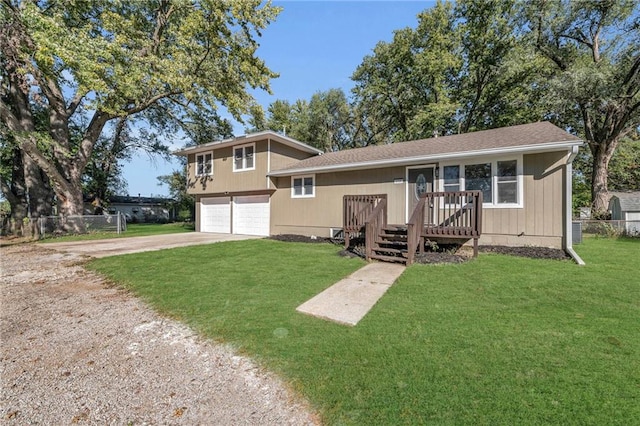 split level home featuring a front lawn, a wooden deck, and a garage