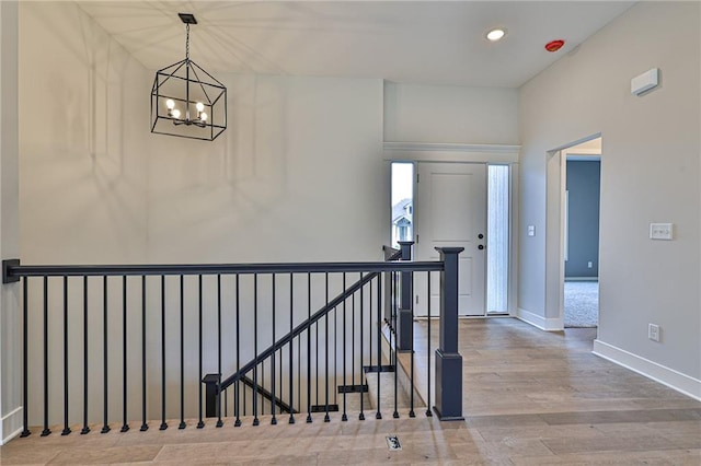 hallway featuring light hardwood / wood-style floors and a notable chandelier