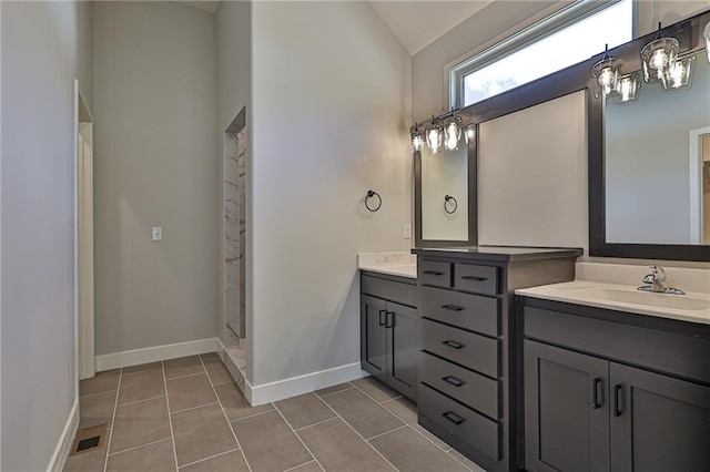 bathroom with walk in shower, vanity, vaulted ceiling, and tile patterned floors