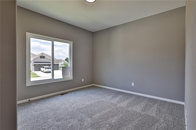 empty room with baseboards, visible vents, and carpet flooring