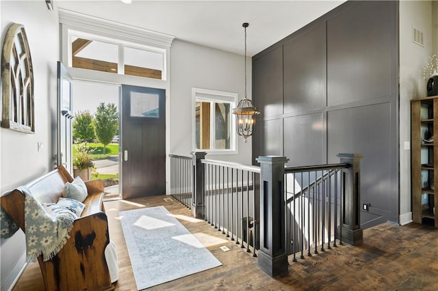 entrance foyer featuring a wealth of natural light, dark hardwood / wood-style floors, and an inviting chandelier