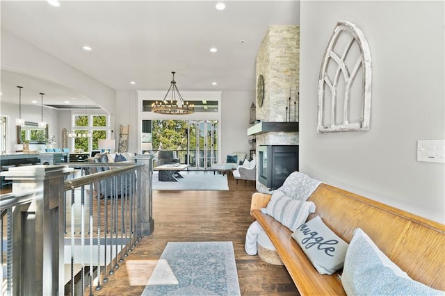 living room featuring a chandelier, a fireplace, and hardwood / wood-style flooring