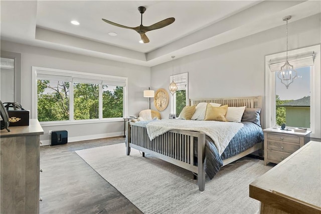 2804 NW Nutall Ct, Lees Summit, MO 64081 - bedroom featuring a raised ceiling, wood finished floors, recessed lighting, a ceiling fan, and a chandelier