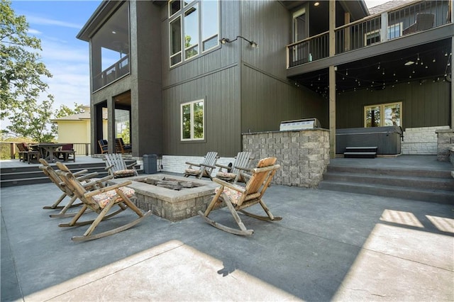 view of patio featuring an outdoor fire pit and a balcony