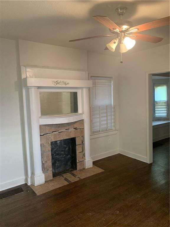 unfurnished living room with ceiling fan, a fireplace, and dark wood-type flooring