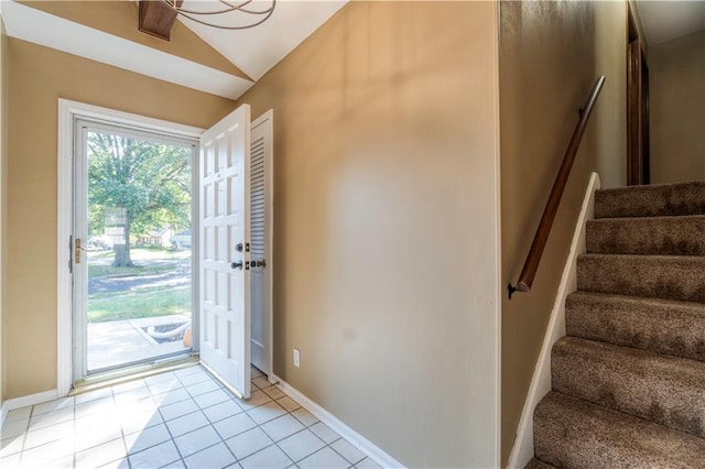 doorway featuring lofted ceiling and light tile patterned floors