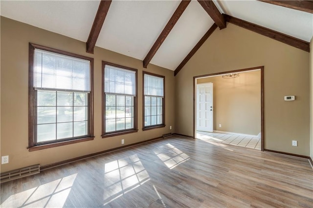 spare room featuring beamed ceiling, high vaulted ceiling, and light hardwood / wood-style flooring