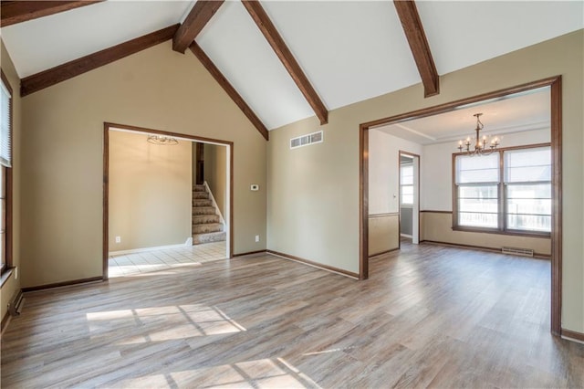 unfurnished living room with high vaulted ceiling, beam ceiling, light hardwood / wood-style floors, and a chandelier