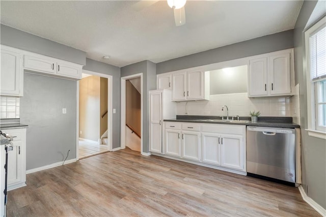 kitchen featuring sink, dishwasher, white cabinetry, backsplash, and light wood-type flooring