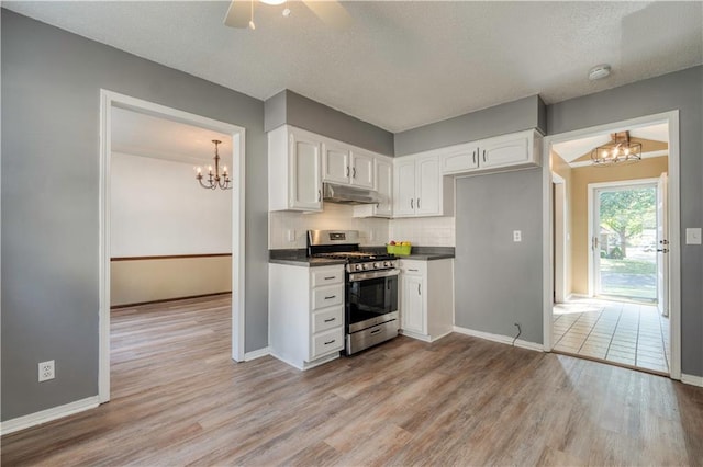 kitchen with stainless steel gas stove, backsplash, light hardwood / wood-style floors, and white cabinets