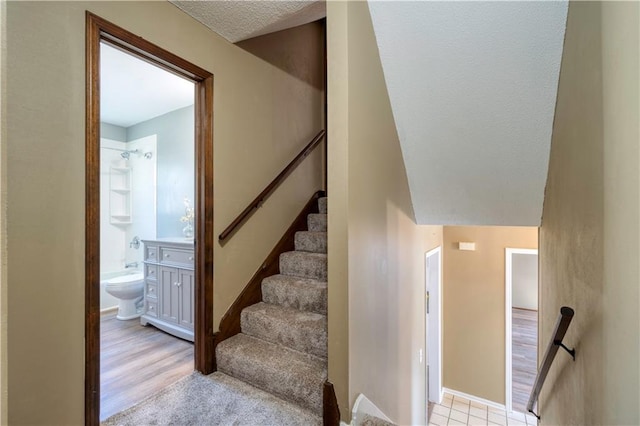 stairs featuring a textured ceiling