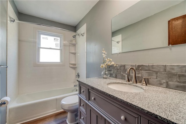 full bathroom with tiled shower / bath combo, vanity, and toilet