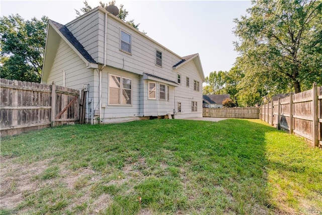 rear view of property with a patio and a lawn