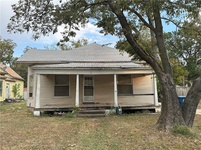 rear view of property with a yard and a porch