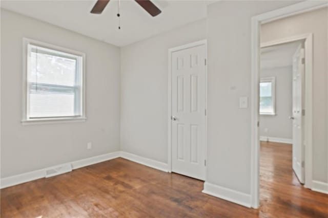 unfurnished bedroom with ceiling fan and dark hardwood / wood-style floors