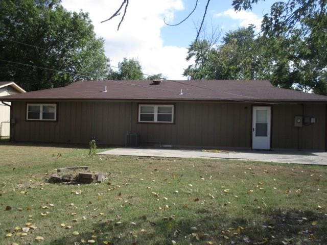 rear view of house featuring a lawn, cooling unit, and a patio area