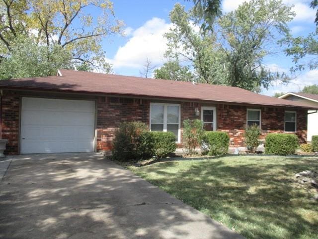 single story home with a front yard and a garage